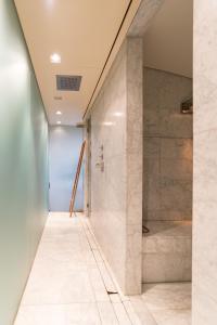 a walk in shower in a bathroom with marble tiles at Wellness Apartment on the Wharf Utrecht in Utrecht
