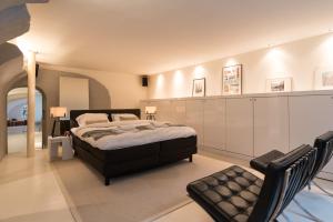 a large bedroom with a bed and a chair at Wellness Apartment on the Wharf Utrecht in Utrecht