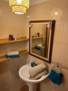 a bathroom with a sink and a mirror and towels at Gran Relax Alcala Appartement in Alcalá +14 photos