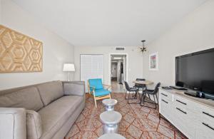 a living room with a couch and a flat screen tv at Camelot By The Sea 1206 in Myrtle Beach
