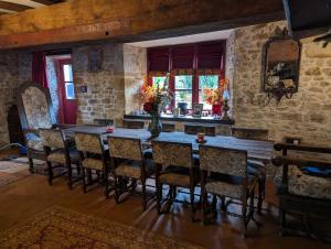 a dining room with a wooden table and chairs at Chateau De Montmagner in Arnac-la-Poste