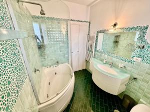 a bathroom with a tub and a toilet and a sink at Seaside Suite in Civitavecchia +13 photos