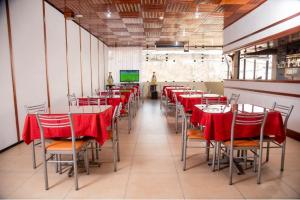 comedor con mesas y sillas rojas y TV en Hotel Oro Verde & Suites en Iquitos