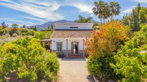 a small white house with mountains in the background at Cubo's Finca Vallehermoso in Alhaurín el Grande