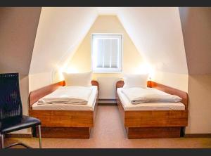 two beds in a room with a window at Fischer Haus in Norderney