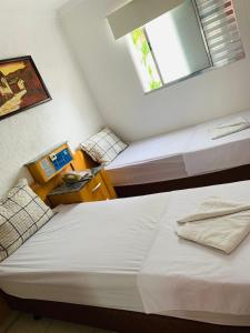 two beds in a room with a window at Hotel Mooca in São Paulo