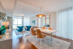 豐沙爾的住宿－Royal Sea View III，一间配备有白色桌子和蓝色椅子的用餐室