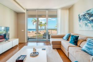 uma sala de estar com um sofá e uma televisão em Royal Sea View III no Funchal