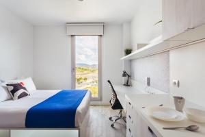 a bedroom with a bed and a desk and a sink at Soto House Pamplona in Pamplona