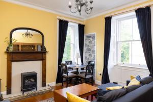 a living room with a couch and a fireplace at Edinburgh Holyrood Park Views Apartment in Edinburgh