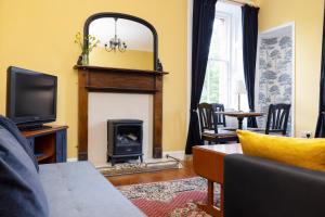 a living room with a fireplace and a tv at Edinburgh Holyrood Park Views Apartment in Edinburgh