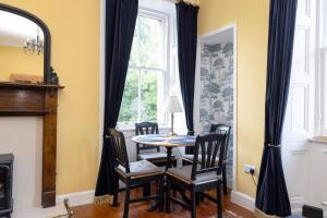 Edinburgh Holyrood Park Views Apartment في إدنبرة: غرفة طعام بها طاولة وكراسي ونافذة +21 صورة