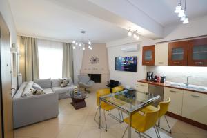 a kitchen and living room with a couch and a table at Garden Apartment next to the Mall -Private Parking in Athens