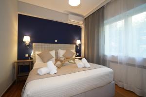 1 dormitorio con 1 cama grande con almohadas blancas en Garden Apartment next to the Mall -Private Parking, en Atenas