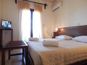 a hotel room with two beds and a window at Philoxenia in Kavála