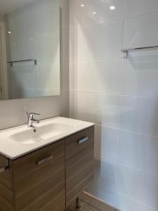 y baño con lavabo y espejo. en Apartaments Turístics Residencia Vila Nova, en Vilanova i la Geltrú