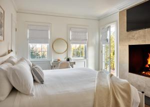 a white bedroom with a fireplace and a bed at EHP Resort & Marina in East Hampton