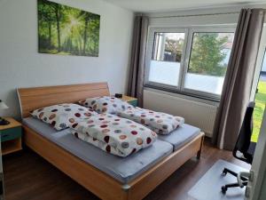 sypialnia z 2 łóżkami z poduszkami i oknem w obiekcie Ferienwohnung Dörnbergblick Klinge w mieście Calden