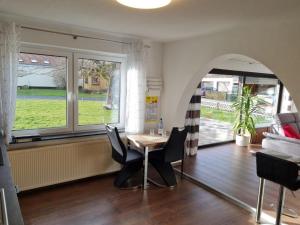 a dining room with a table and chairs and a window at Ferienwohnung Dörnbergblick Klinge in Calden