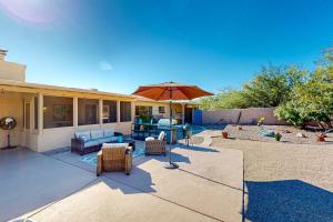 a patio with furniture and an umbrella on a house at Sabino Canyon Hideaway in Tucson