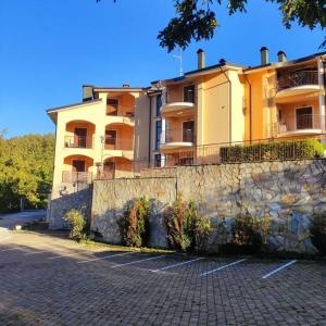 um grande edifício em frente a uma parede de pedra em casa di Alice, castel del giudice em Isernia