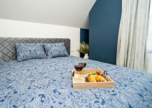 a tray of fruit and a glass of wine on a bed at Fort63 Studio in Kaunas