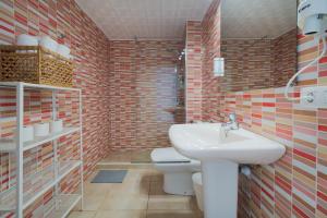 a bathroom with a white sink and a toilet at Sabbia Suites Pleamar in Puerto del Carmen