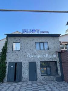 a building with a sign that reads queens on the korean at InJoy hostel in Shymkent