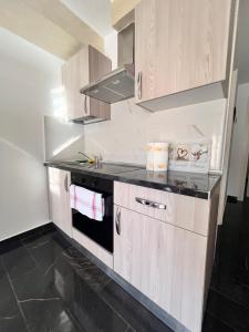 a kitchen with wooden cabinets and a stove top oven at Edificio Sofia in Las Galletas