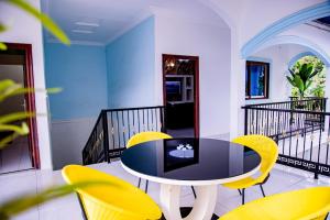 a dining room with a table and yellow chairs at PINORICH VILLA-Buea in Buea
