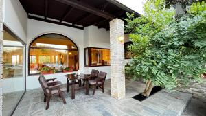 an outdoor patio with a wooden table and chairs at Philoxenia in Kavála