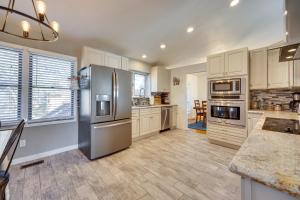 uma cozinha com electrodomésticos de aço inoxidável e armários brancos em Spacious Colorado Springs Home with Fire Pit! em Colorado Springs