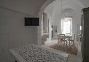 Cette chambre blanche comprend un lit et une table. dans l'établissement Casalice - Second Home, à Ostuni