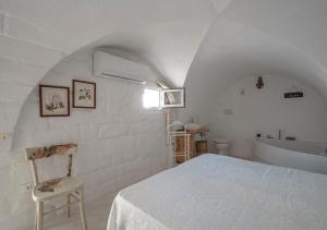 - une chambre blanche avec un lit et une baignoire dans l'établissement Casalice - Second Home, à Ostuni
