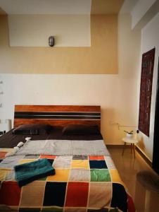 Un dormitorio con una cama con una colcha colorida. en The Sunrise Inlet, en Rājpur