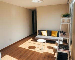 sala de estar con sofá y escalera en Acogedor departamento con amplia terraza, en Lima