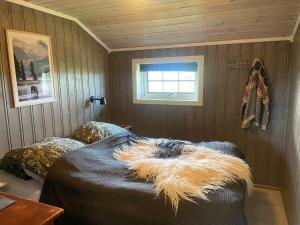Un dormitorio con una cama con una manta. en Hytte med Anneks og fantastisk utsikt på Ljøsheim, en Mesnali