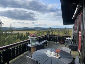 Hytte med Anneks og fantastisk utsikt på Ljøsheim في Mesnali: فناء على طاولة وكراسي على شرفة