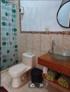 a bathroom with a white toilet and a sink at CASA VILLA SOL in Tumbes