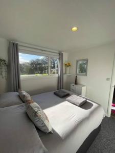 a bedroom with a large bed with a window at Villa 22 Lanteglos Hotel in Lanteglos