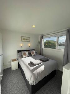 a bedroom with a large bed and a window at Villa 22 Lanteglos Hotel in Lanteglos
