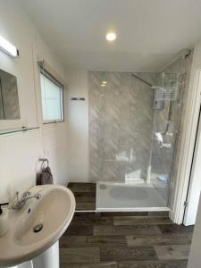 a white bathroom with a shower and a sink at Villa 22 Lanteglos Hotel in Lanteglos +16 photos