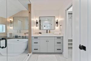 Baño blanco con bañera, lavabo y espejo en NEW - Luxury 5 br Beach Retreat, en Ponte Vedra Beach 73 fotos más
