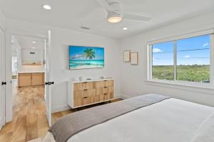 Un dormitorio blanco con una cama y una ventana. en NEW - Luxury 5 br Beach Retreat, en Ponte Vedra Beach