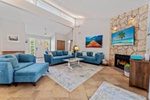 a living room with blue couches and a fireplace at Saltwater Oasis - Large Pool in Jacksonville Beach