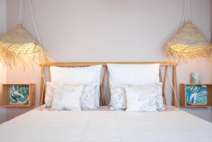 a bedroom with a bed with white sheets and pillows at Le Farniente, belle maison près du port in La Rochelle