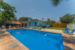 a large blue swimming pool in front of a house at Saltwater Oasis - Large Pool in Jacksonville Beach
