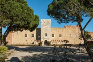 an old castle with trees in the foreground at BEAU T4 100M2 PALAIS DES ROIS DE MAJORQUE in Perpignan