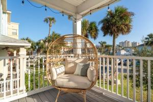 einen Korbstuhl auf einer Veranda mit Palmen in der Unterkunft Ocean views, Elevator, Game Room, Two balconies in Jacksonville Beach