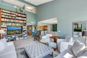 a living room with white furniture and a tv at Golf Front - Sawgrass Gate Community in Ponte Vedra Beach